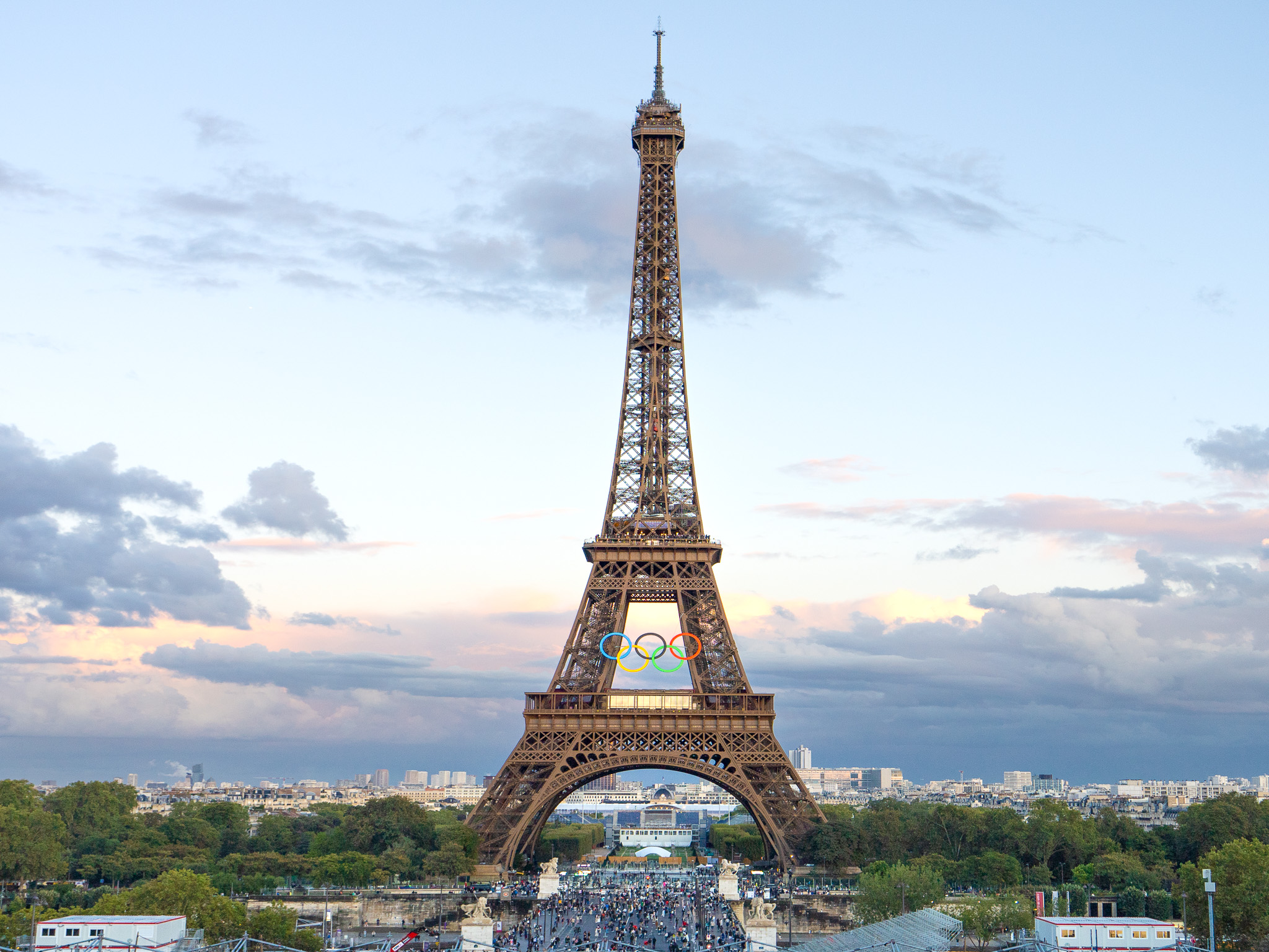 a large tower with a crowd of people walking around with Eiffel Tower in the background