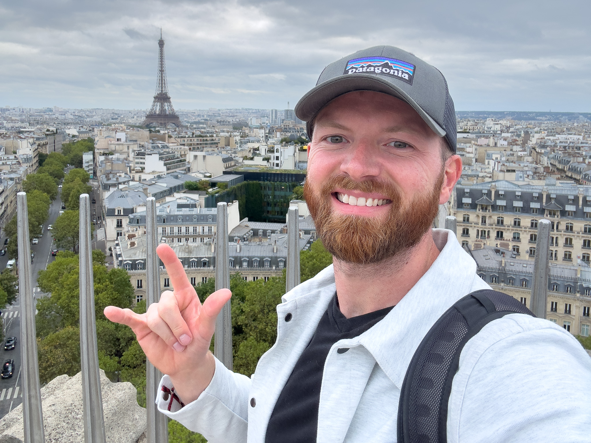 a man taking a selfie with a city behind him