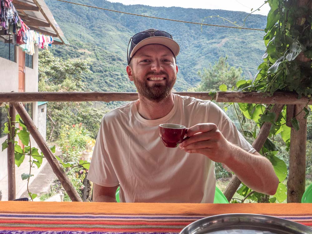 a man sitting at a table with a cup of coffee