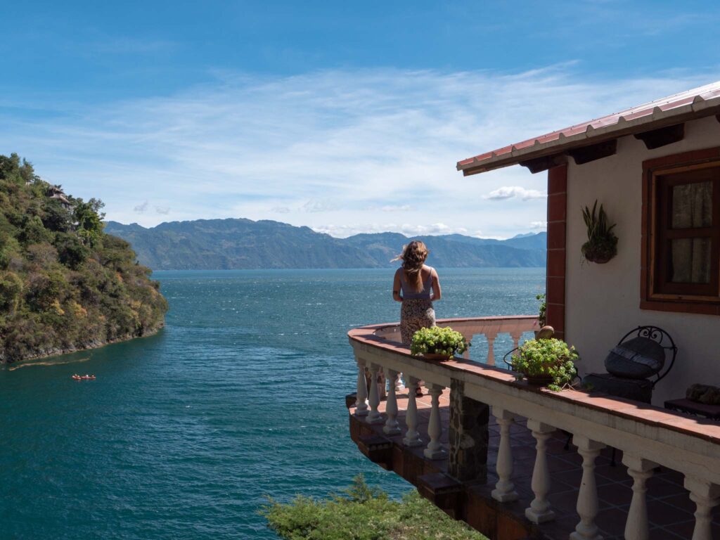 a woman standing on a balcony overlooking a body of water