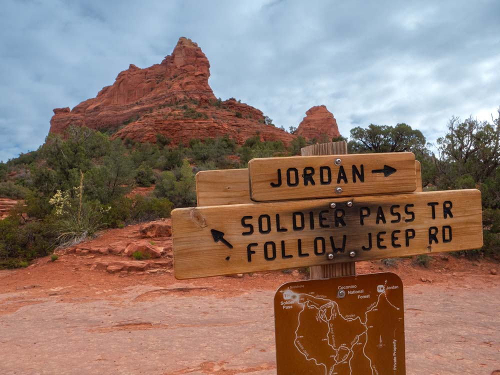 a sign in front of a red rock