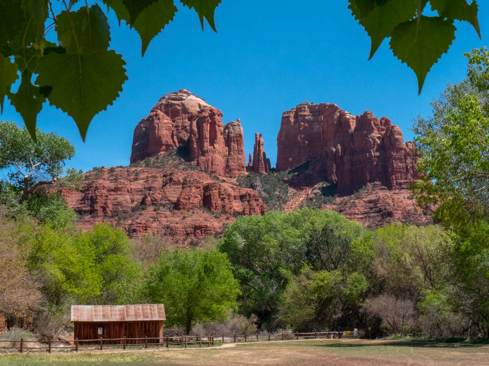 a red rock mountain with a cabin in the background with Cathedral Rock in the background