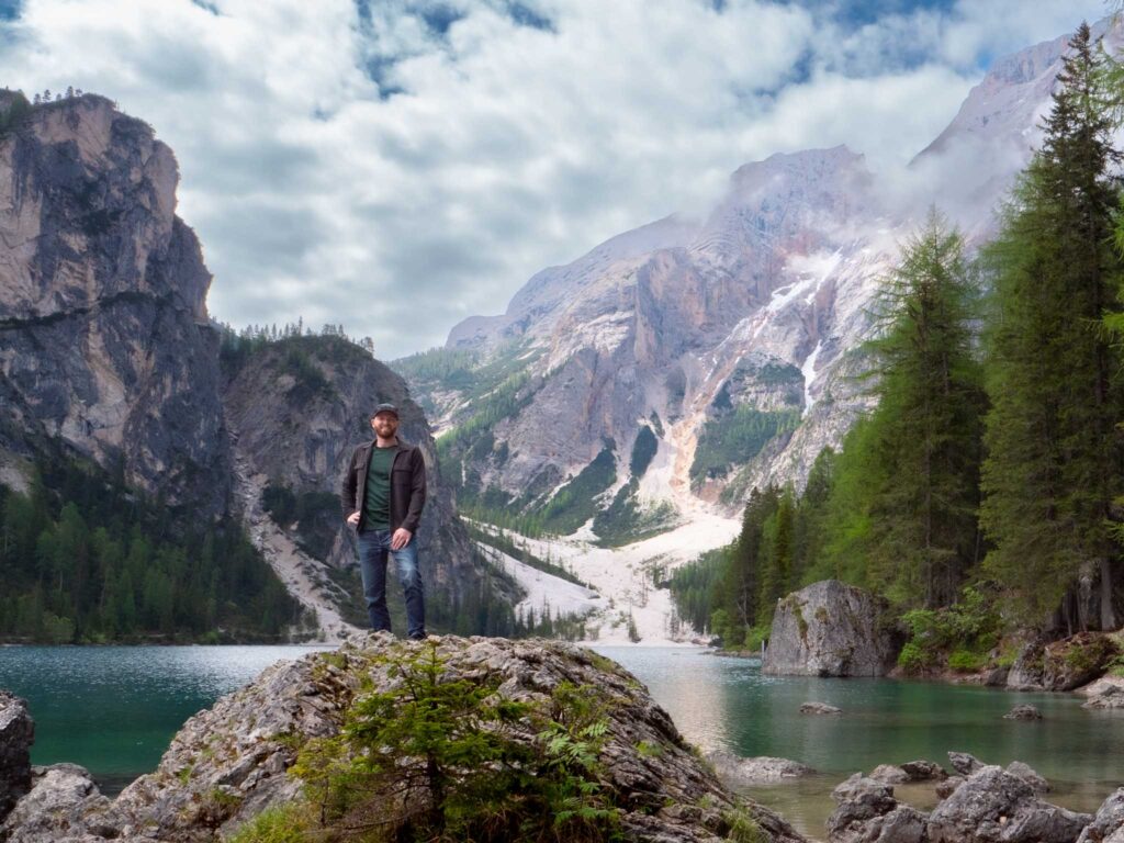 a man standing on a rock in front of a lake