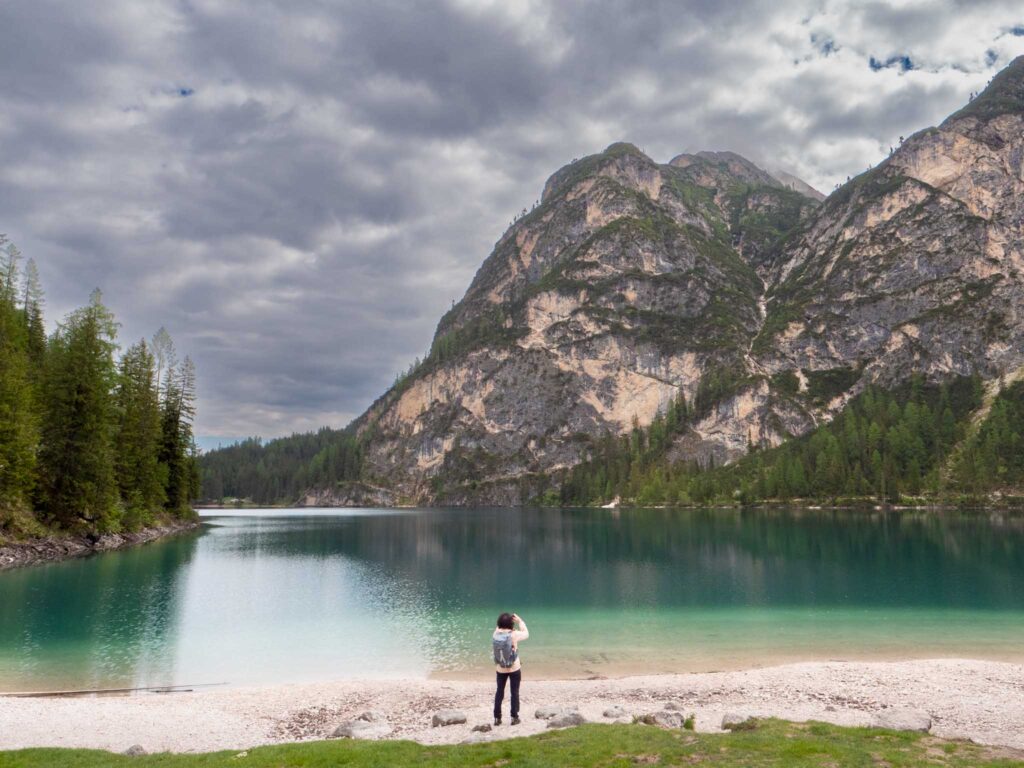 Woman taking a photo at Lago di Braies Italy