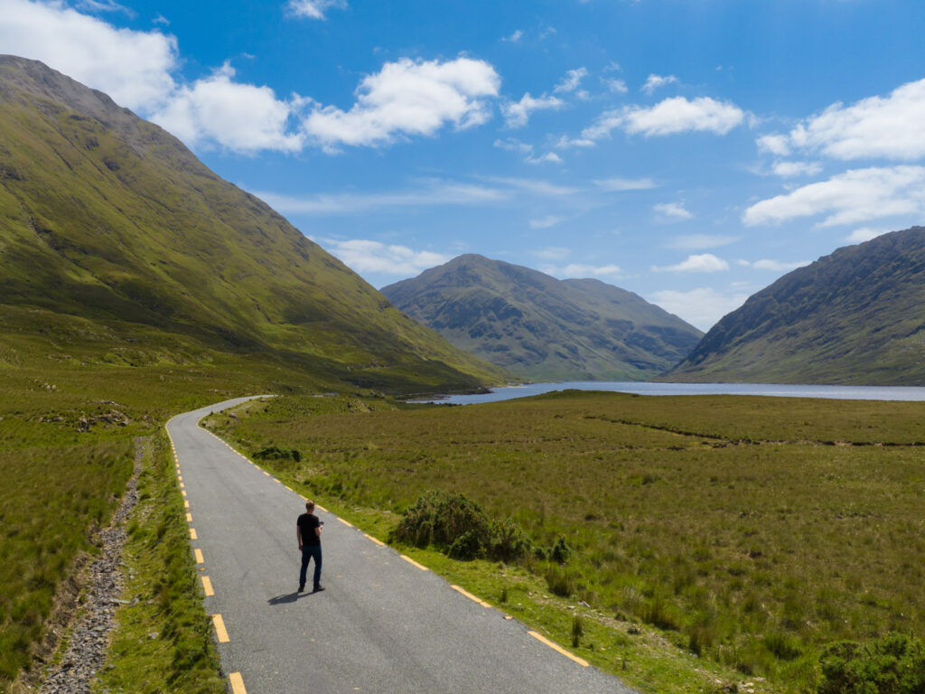 Man standing in road with mountains in background