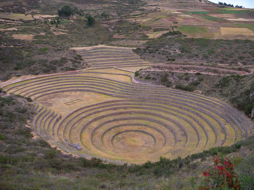 a circular stone structure on a hill with Moray in the background