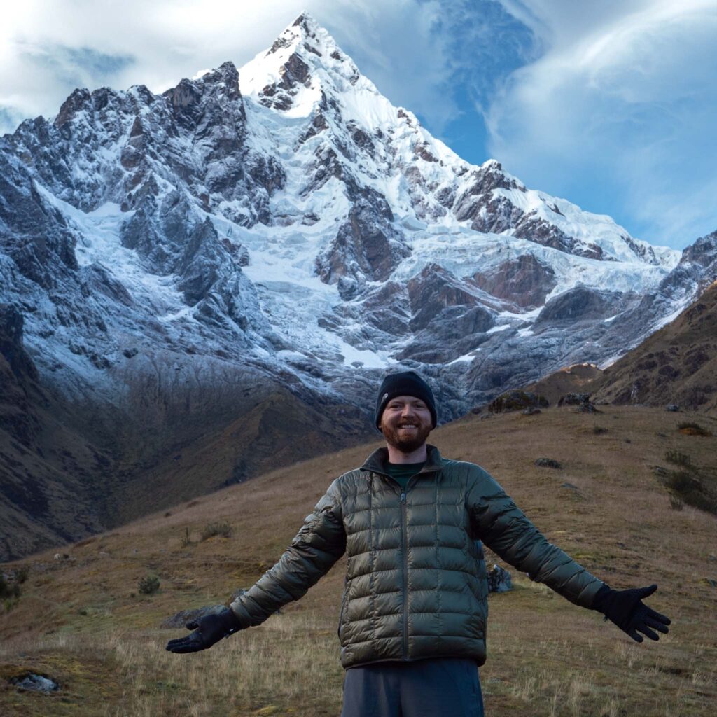 a man standing in front of a snowy mountain