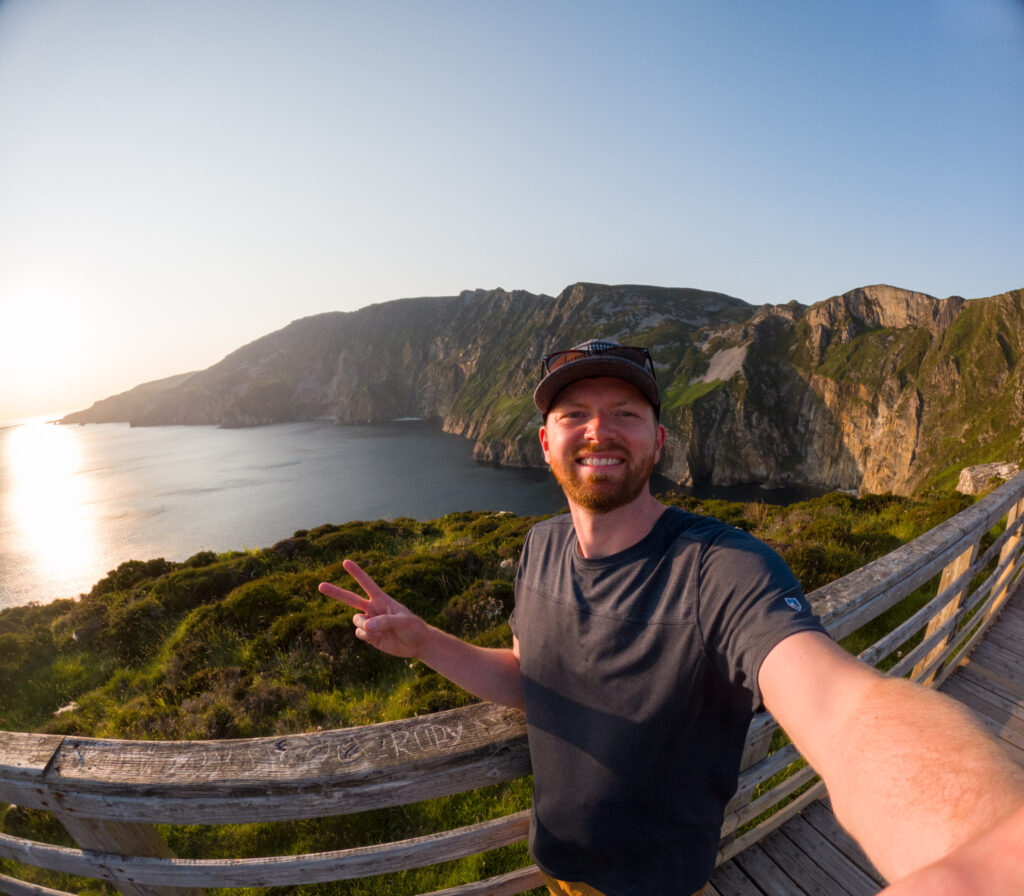 Man taking selfie at Slieve League Cliffs during sunset