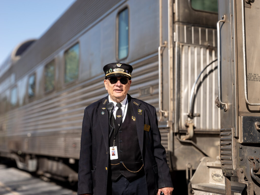 a man in a uniform standing next to a train