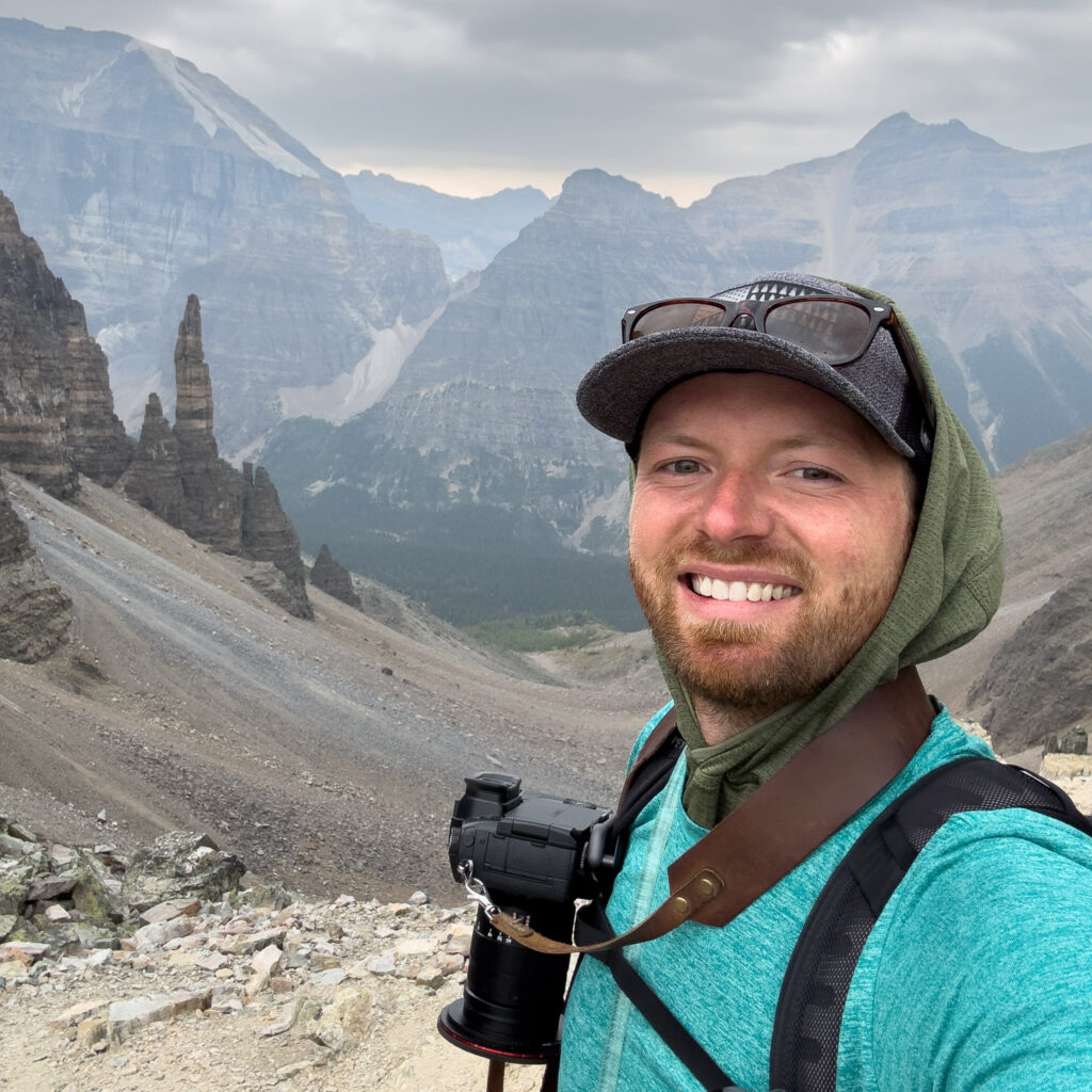 a man taking a selfie with mountains in the background