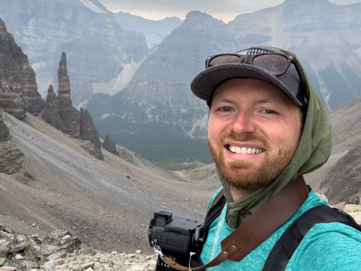 a man taking a selfie with mountains in the background