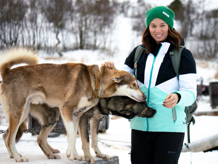 Woman petting huskies after her husky hike in Tromso Norway