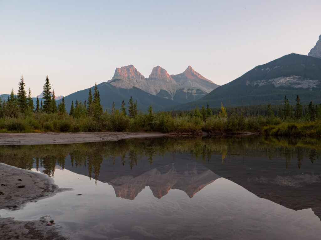Reflection photography of the Three Sisters Peaks in Canmore Alberta Canada