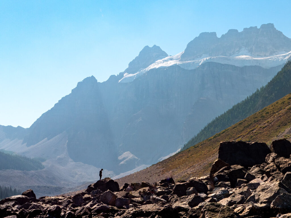 a person standing on rocks in front of a mountain