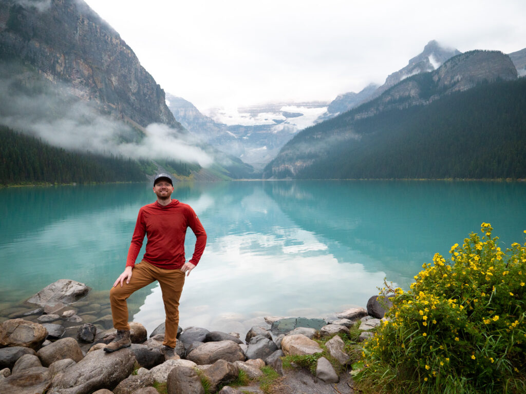 a man standing on rocks by a lake