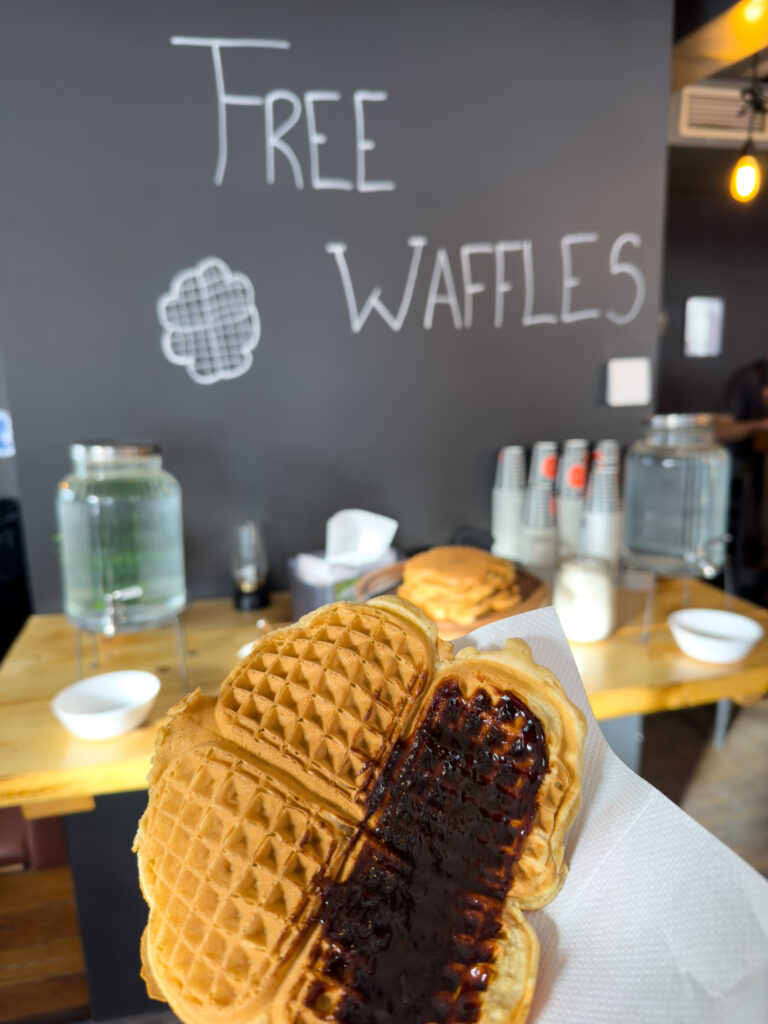 A jellied waffle in front of a free waffles sign
