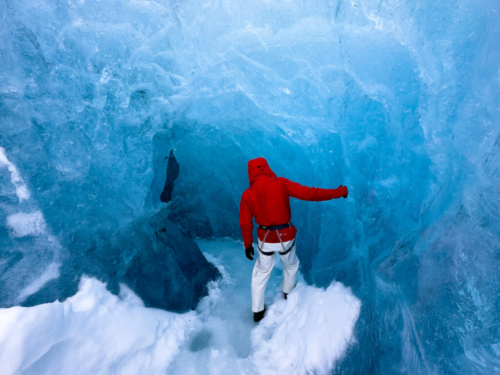 Glacier hike guide exploring a blue ice cave