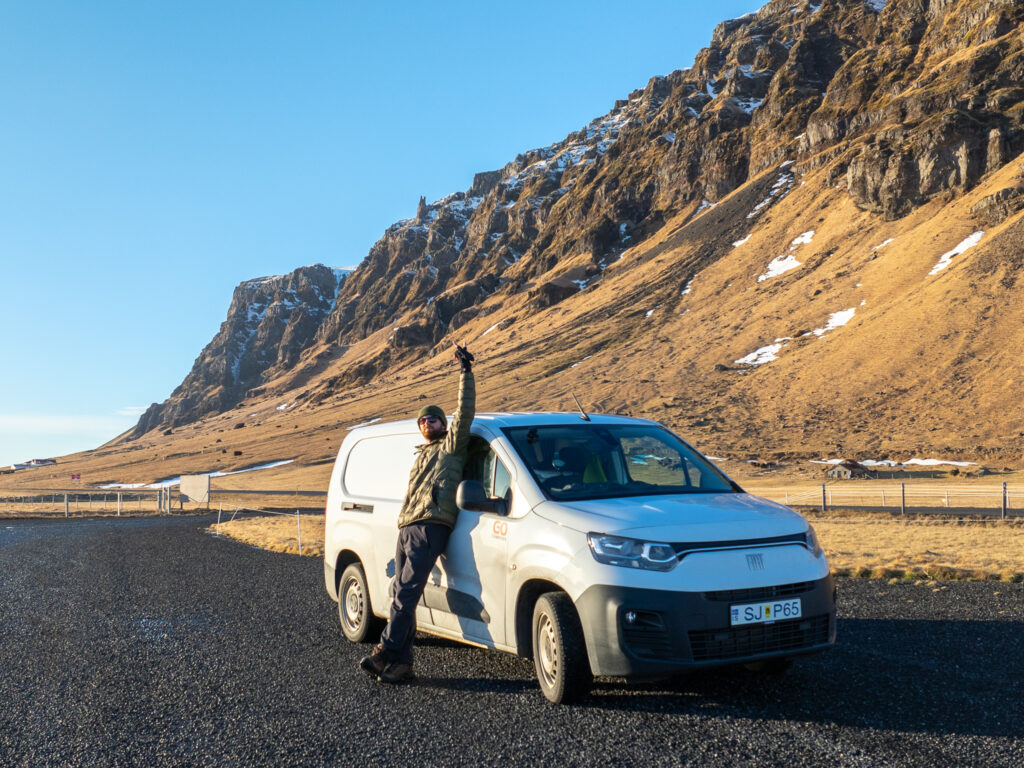 Man standing in front of a camper van in Iceland