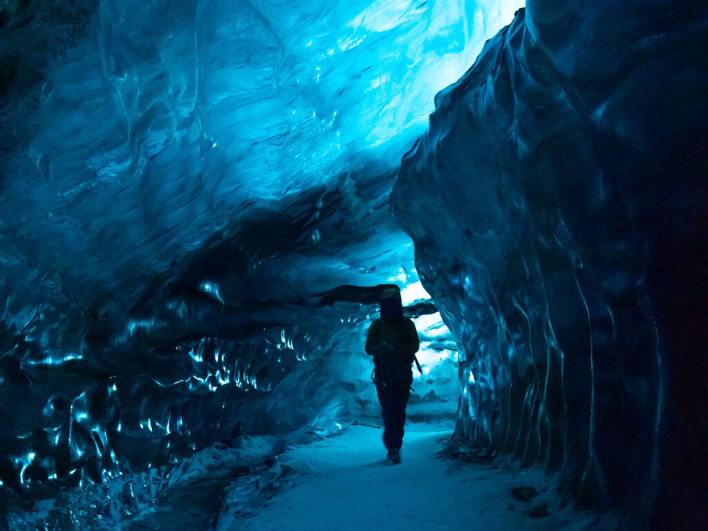 Dark ice cave with a shadowed person in the middle