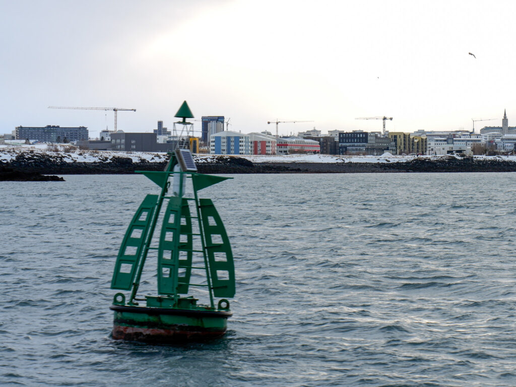 Green buoy floating near Reykjavik Harbor in Iceland
