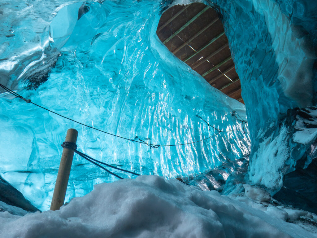 Vivid turquoise glacial ice cave entrance
