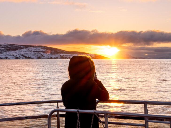 A woman enjoying sunset during an Arctic Whale watching safari