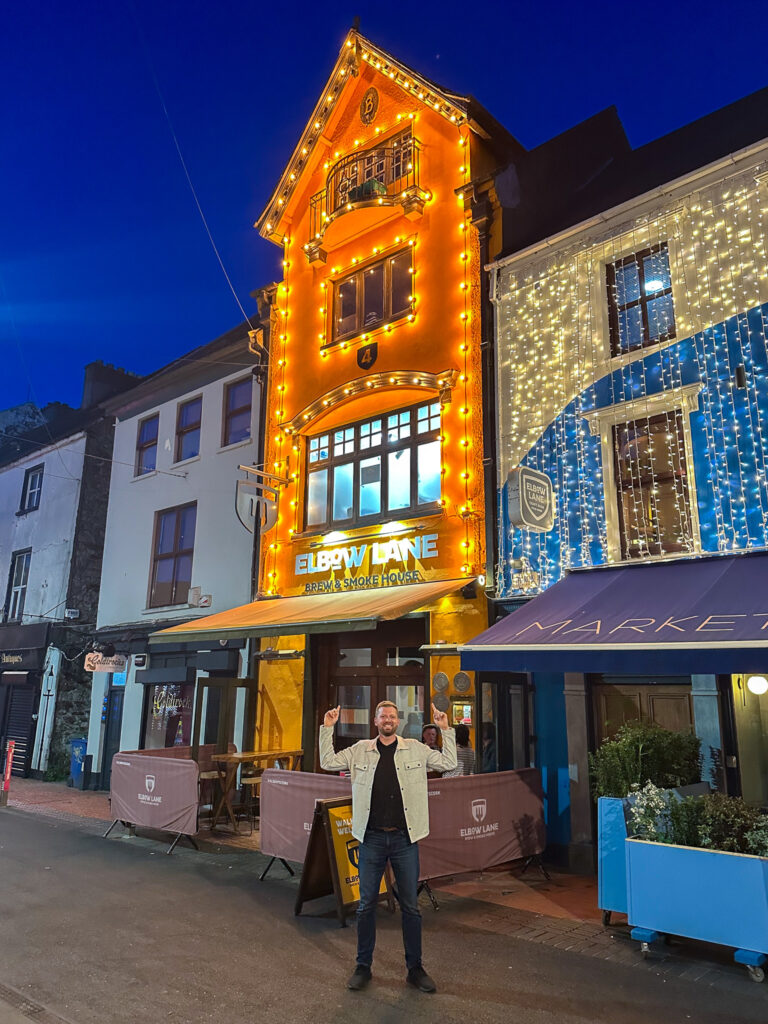 Man standing in front of a brightly lit restaurant