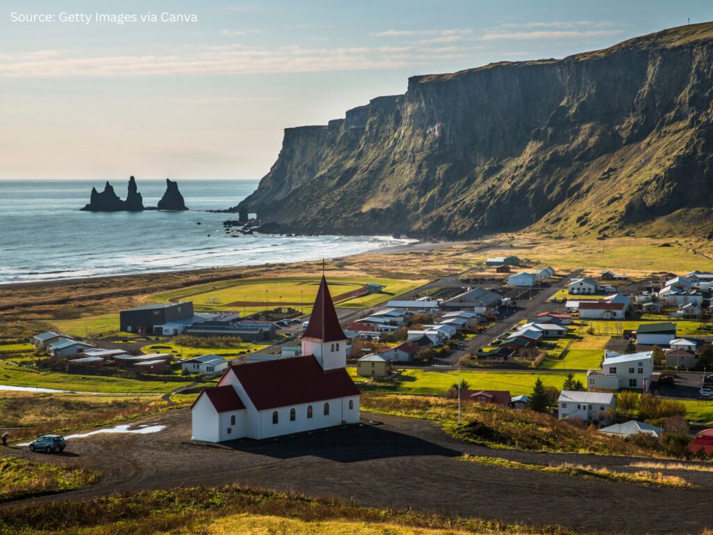 a small town with a red roof and a small town with a beach and water