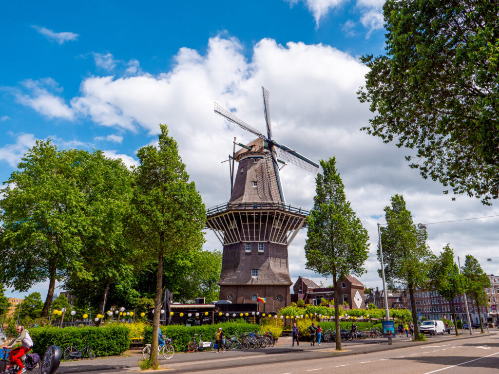 a windmill with trees and people in the background