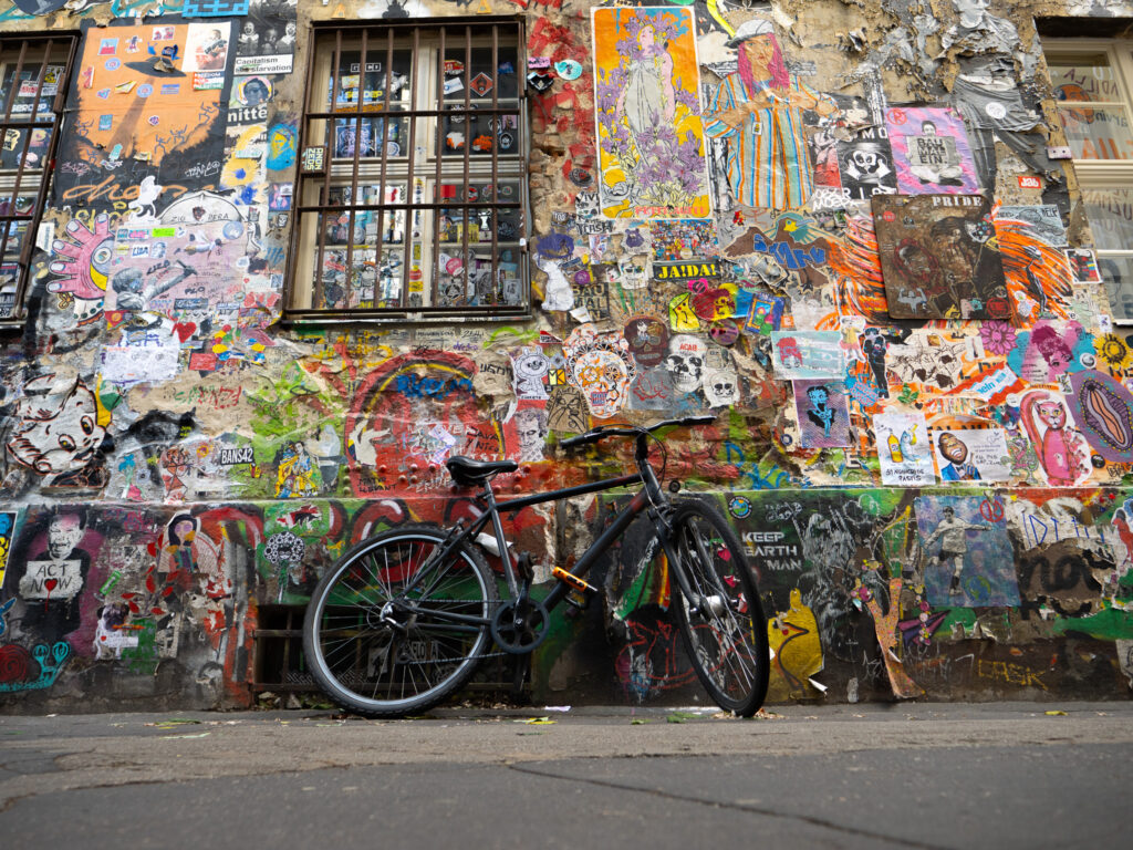 a bicycle leaning against a wall with many posters on it