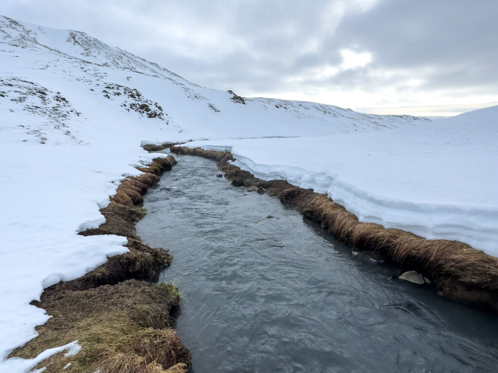 a stream running through a snowy area