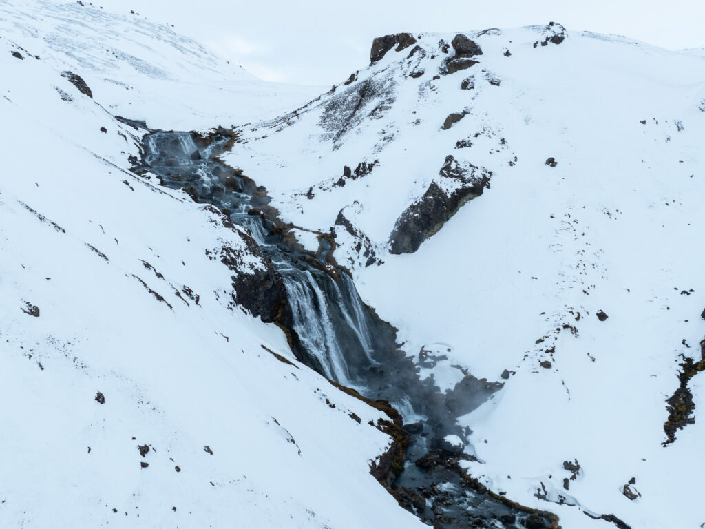 a waterfall in a snowy mountain